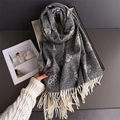 Détail du motif jacquard camélia et des franges sur un châle pashmina gris - Gris clair