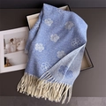 Détail de l'écharpe camélia bleu clair avec des franges crème et texture tricotée - Bleu