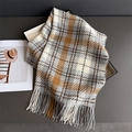 Detail of soft plaid scarf with long fringe tassels in grey and beige on a stylish tray - Grey Brown