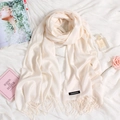 Elegant cream white cashmere scarf with tassels and brand label on a stylish background - Cream White (FYR150-36)