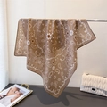 Detail of coffee brown paisley scarf with sun pattern and elegant draped texture - Tan