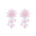 Vue détaillée des boucles d'oreilles faites main avec perles roses et pompons fleuris - Rose