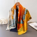 Detail van artistieke zijden sjaal met olieverfprint gedrapeerd aan een hanger - Oranje