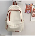 Detail of a minimalist off-white nylon backpack with red accents hanging on a door handle - Single Bag / White & Red