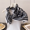 Detail of a black and white paisley silk scarf tied on a chic white knit vest outfit - Black (FG87-2)