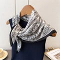 Detail of elegant black and white herringbone silk scarf tied on a navy knit vest - 68*68cm / Black