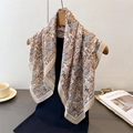 Detail shot of elegant paisley pattern silk-feel scarf draped on a wooden hanger - 68*68cm / Beige