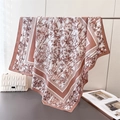 Detail of silk-like scarf featuring rust red bamboo prints on a white background - 90x90cm / Brown