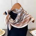 Detail of paisley silk scarf styled on a blue vest with an elegant lifestyle setting - One Size (66-70cm) / Brown (FG88-1)