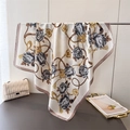 Elegant floral and golden chain print silk satin square scarf displayed on a stand - Beige