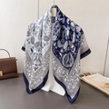 Detail of satin square scarf featuring navy paisley print draped on an ivory mannequin - Large Square / Navy Blue