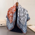 Detail of paisley print satin scarf showing elegant drape and rolled edge finish - Large Square / Orange
