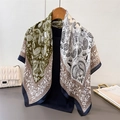 Detail of olive green and ivory paisley satin silk scarf on a wooden hanger with accessories - Large Square / Green