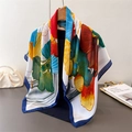 Detail eines Seidenschals mit Ginkgo-Blatt-Druck an einem Kleiderbügel aus Holz - Marineblau