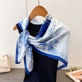 Detail of silk scarf with blue and white floral print draped on a hanger for styling - 90x90cm / Blue