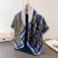 Macro detail of silk-feel scarf with navy paisley and polka dot print on wood hanger - Blue