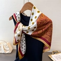 Close-up of silk-feel scarf with gold polka dots and red paisley print on mannequin - Red