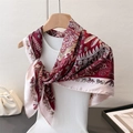 Dettaglio di un foulard in raso vintage con stampe animalier e motivi paisley su gruccia - 90*90cm / Rosso