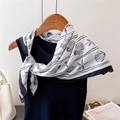Dettaglio di un foulard in seta con stampe di conchiglie nere legato su un top nero - Nero (FG84-1)