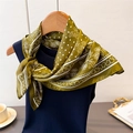 Close-up of olive green silk scarf with white polka dots and paisley patterns - Green