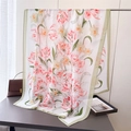 Detail of floral silk scarf showing pink tulips and green edges on a minimalist table - Pink