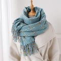 Detail of blue knit scarf with colorful dots and long tassels on white coat - Blue