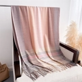 Dettaglio di sciarpa morbida effetto cashmere con frange su una sedia bianca - Rosa Chiaro