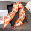 Narrow silk twilly with orange fruit print and vibrant orange border on black tray - Orange Citrus Print
