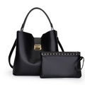 Detalle de set de bolso tipo cubo en cuero negro con herrajes dorados y remaches finos - Negro