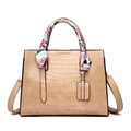Detail of beige crocodile embossed tote bag with colorful silk scarf wrapped on handle - Khaki