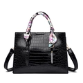 Detail of black crocodile embossed handbag with colorful silk scarf on the top handle - Black