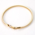 Flat lay of a polished gold stainless steel snake chain bracelet with lobster clasp - 19cm / Gold