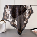 Detailed texture of black and gold floral silk scarf showing elegant drape and semi-sheer fabric - Black