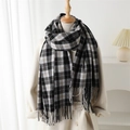 Plaid cashmere-like scarf with fringe detail over a beige coat for a stylish winter look - Black and White