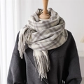 Detail of classic beige and grey plaid scarf with long tassels on a winter wool coat - Off-white