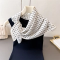 Detail of white scarf with black polka dot print paired with navy blue sleeveless top - White