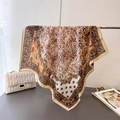 Elegant floral paisley patterned square scarf draped on a gold rack in warm brown tones - 68*68cm / Beige