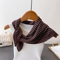 Detailed view of coffee brown polka dot silk scarf styled on a white tank top - Coffee