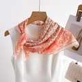 Detail of silk-texture paisley square scarf in peach and orange tied on a white top - 70*70cm / FG15-3 Honey Pink Paisley