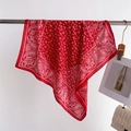 Detail of red paisley silk-like scarf draped on a metal bar with elegant floral patterns - FG15-4 Red