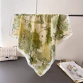 Floral forest print silk scarf in green and cream hanging on a metal rack - Forest Green (FG35-1)