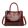 Detail of red crocodile pattern texture and golden hardware on the handbag - Burgundy