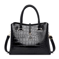 Detail of glossy black crocodile pattern handbag with golden fan-shaped pendant charm - Black