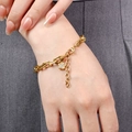 Detail of 18K gold stainless steel oval chain bracelet with a micro-set flower pendant - Gold Flower Charm (C0019)