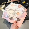 Dettaglio di foulard in seta rosa con motivi a rose e stampa a frange su vassoio - Rosa