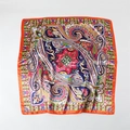 Detailed flat lay of a satin square scarf with paisley floral patterns and orange border - 90x90cm / Orange