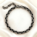 Dettaglio macro delle maglie del bracciale rétro in acciaio inox su tessuto di seta - Bracciale a Catena Curb Nero Vintage / 5.5mm*18+4cm