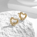 Elegant gold heart earrings with zircon inlay on a white minimalist stone base - Hollow Heart Zirconia Stud Earrings (E0040)
