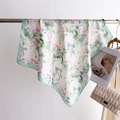 Dettaglio ravvicinato di un foulard in seta a fiori rosa e verdi su supporto in metallo - Verde