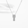 Gros plan d'un pendentif croix géométrique en argent orné de pierres de zircone cubique - Plaque Carrée Acier Sertie de Zircon Forme T